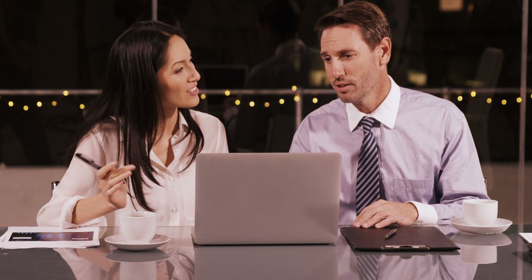 Professionals Collaborating Over Laptop in Modern Cafe