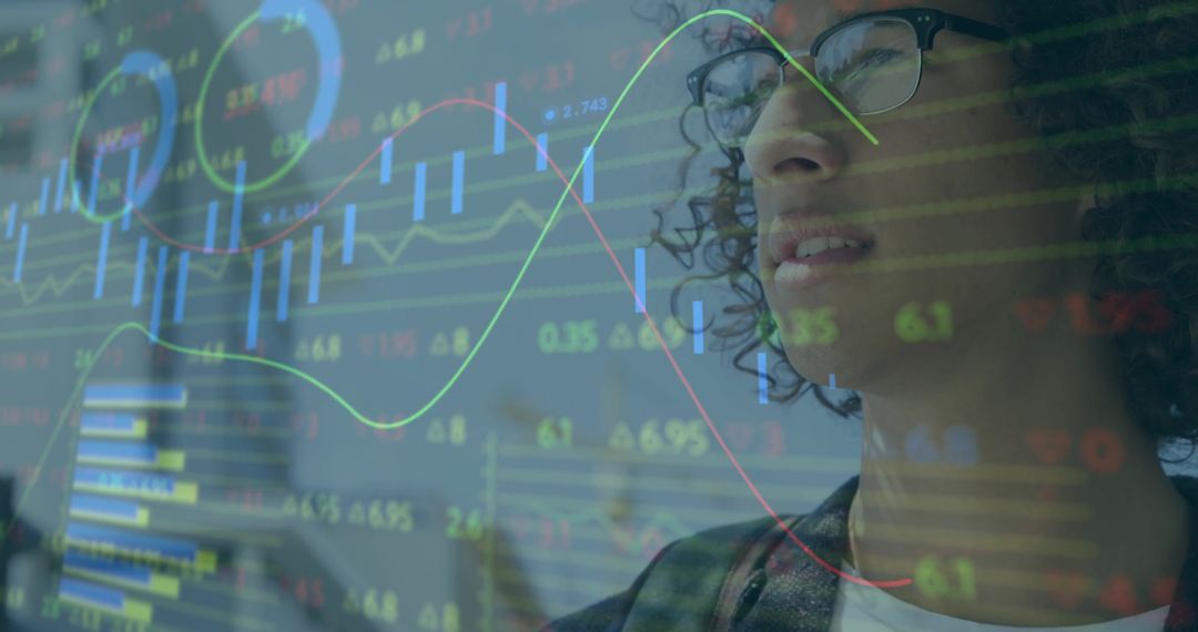 Man with glasses studying transparent market data overlay with trading charts and candlesticks