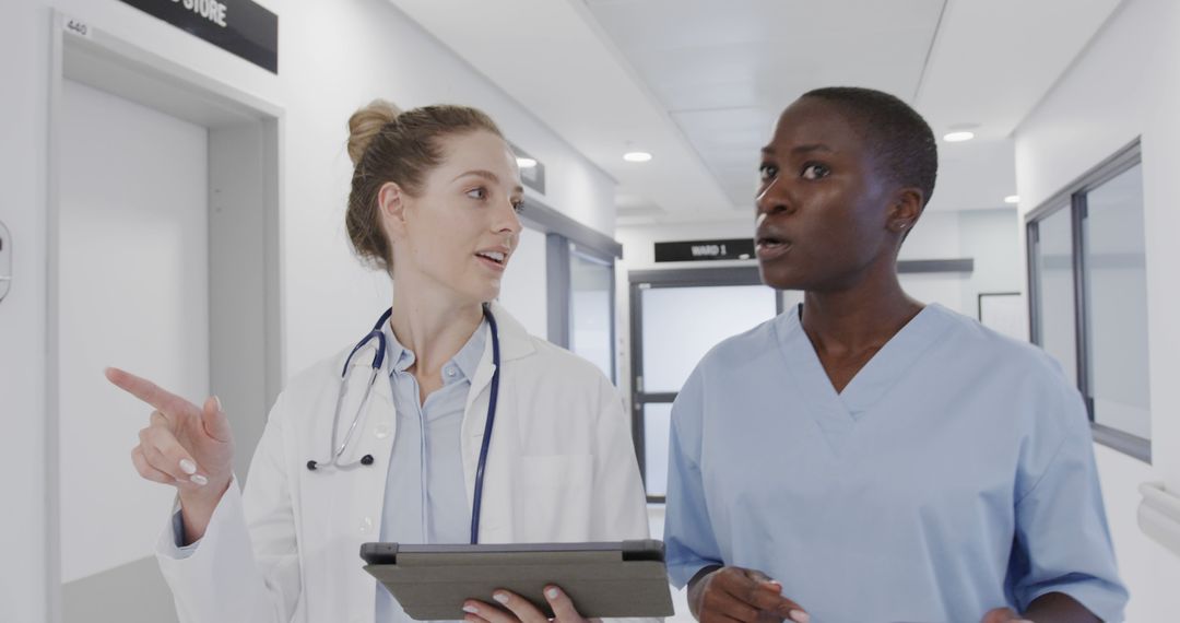 Healthcare Professionals Discussing Duties in Hospital Corridor - Free Images, Stock Photos and Pictures on Pikwizard.com