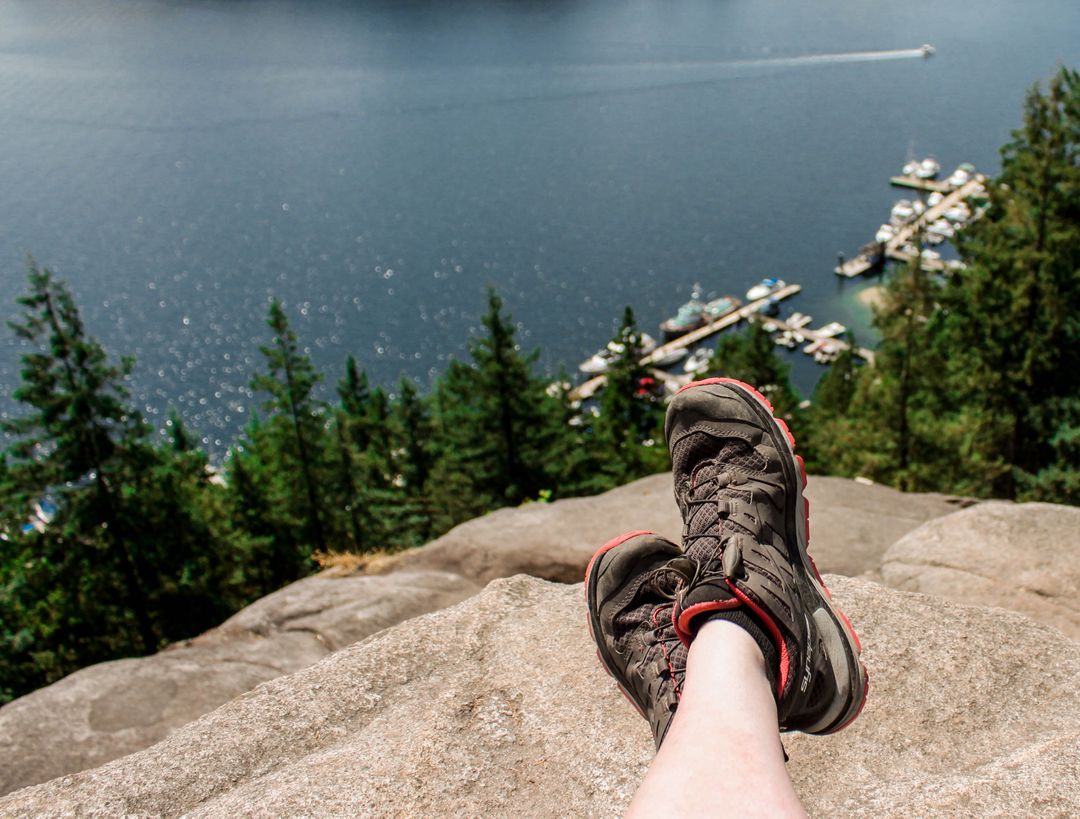 Hiker Resting on Rocky Summit Overlooking Scenic Lake View - Free Images, Stock Photos and Pictures on Pikwizard.com