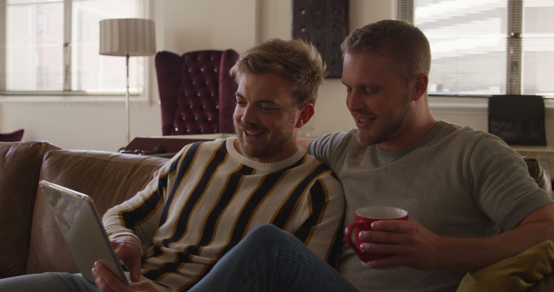 Happy Couple Relaxing with Tablet and Coffee in Modern Apartment