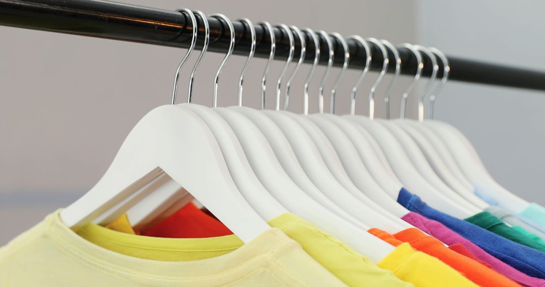 Rainbow Colored T-Shirts on White Hangers in Clothing Store - Free Images, Stock Photos and Pictures on Pikwizard.com