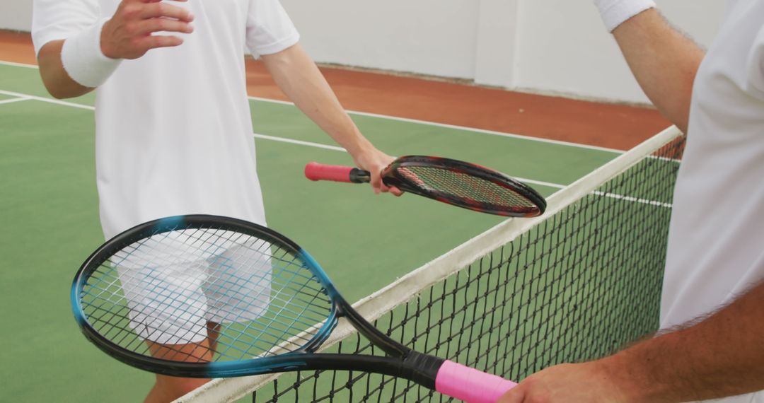 Two Tennis Players Shaking Rackets at Net on Court - Free Images, Stock Photos and Pictures on Pikwizard.com