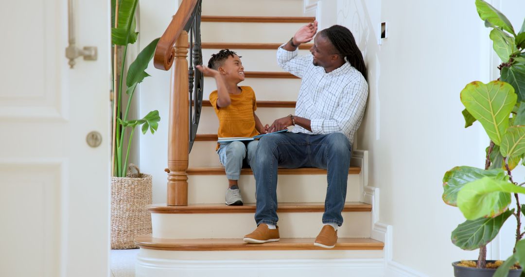 Happy Father and Son Bonding While Reading Indoors