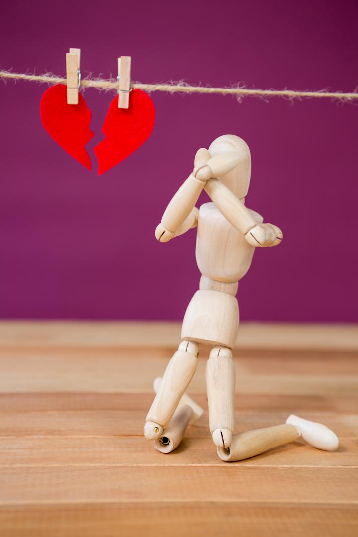 Wooden Figurine Kneeling in Front of Broken Heart - Free Images, Stock Photos and Pictures on Pikwizard.com