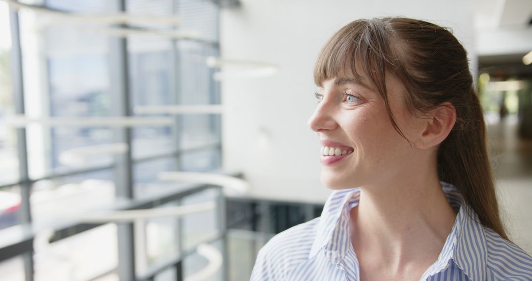 Smiling Businesswoman in Modern Office Looking Inspired