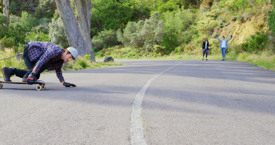 Young man enjoying longboarding on scenic road - Free Images, Stock Photos and Pictures on Pikwizard.com