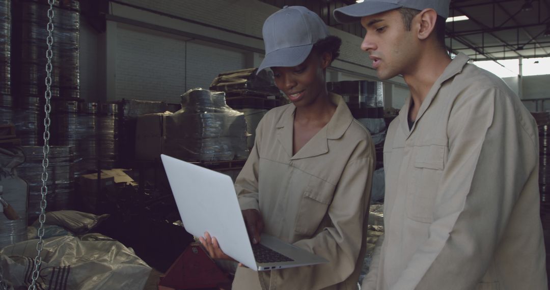 Warehouse Workers in Uniform Examining Information on Laptop - Free Images, Stock Photos and Pictures on Pikwizard.com