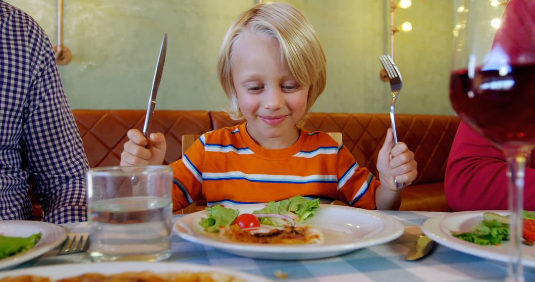 Happy Boy Enjoying Meal in Family Restaurant - Free Images, Stock Photos and Pictures on Pikwizard.com