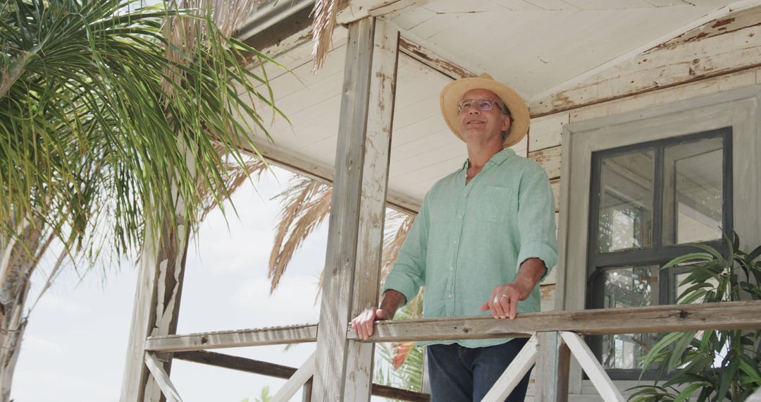 Man Relaxing on Porch of Rustic Beach House - Free Images, Stock Photos and Pictures on Pikwizard.com