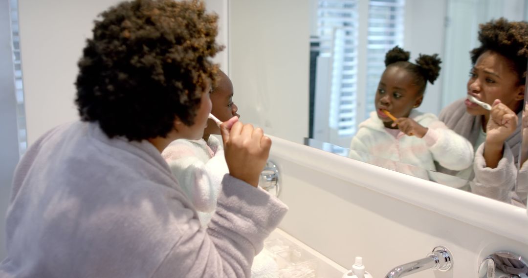 Mother and Daughter Brushing Teeth Together in Modern Bathroom - Free Images, Stock Photos and Pictures on Pikwizard.com