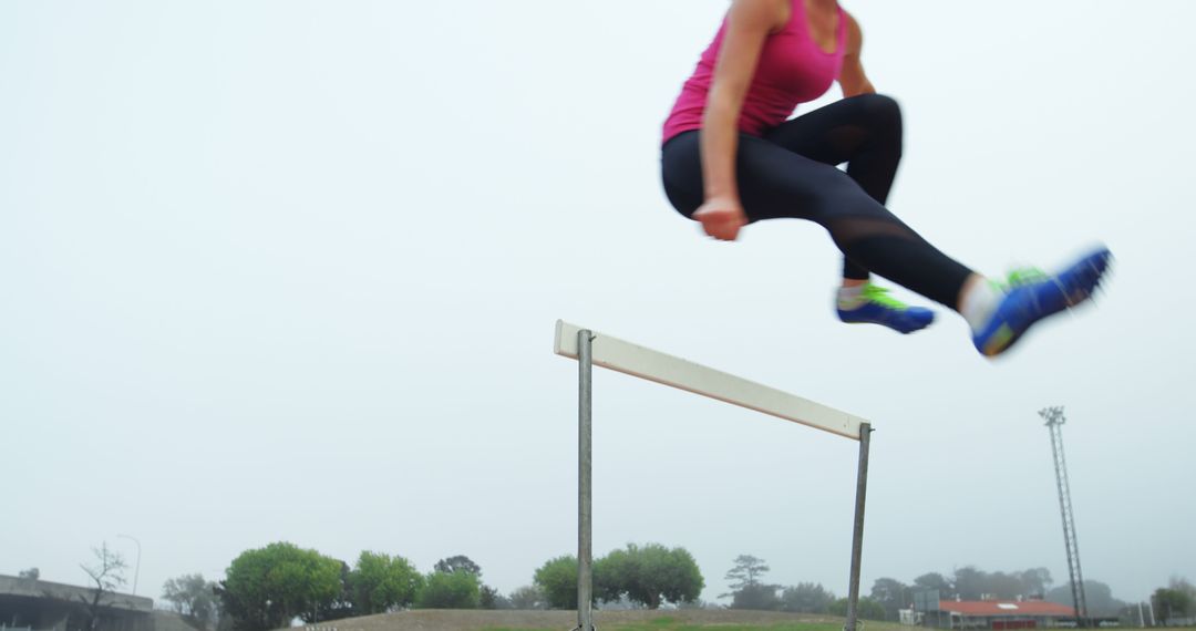 Athletic Woman Mid-air Jumping Over Hurdle in Outdoor Setting - Free Images, Stock Photos and Pictures on Pikwizard.com