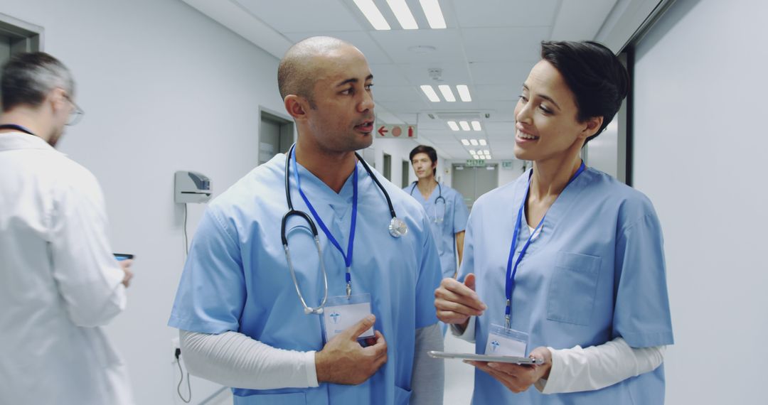 Medical Professionals Collaborating in a Hospital Corridor - Free Images, Stock Photos and Pictures on Pikwizard.com