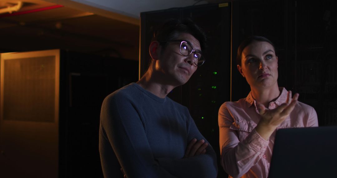 Professionals Analyzing Data in Dark Server Room