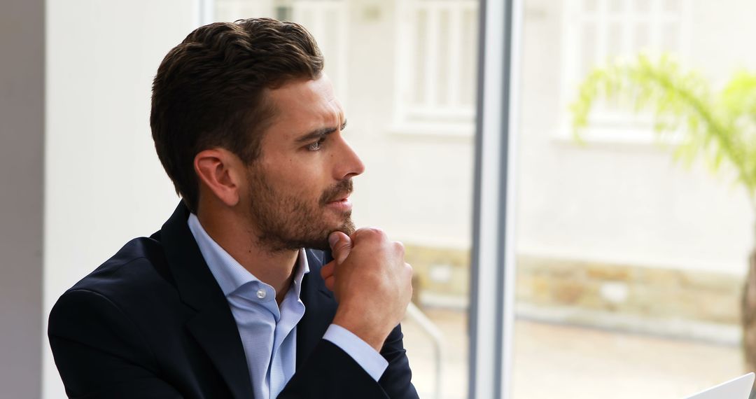 Thoughtful Businessman Looking Out Office Window - Free Images, Stock Photos and Pictures on Pikwizard.com