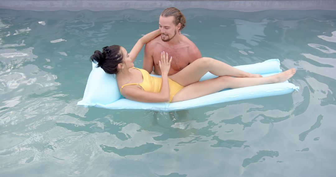 Playful Couple Relaxing on Pool Float