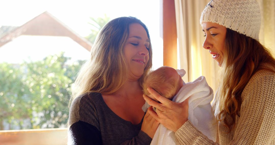 Two Women Admiring Newborn Baby Wrapped in Blanket - Free Images, Stock Photos and Pictures on Pikwizard.com