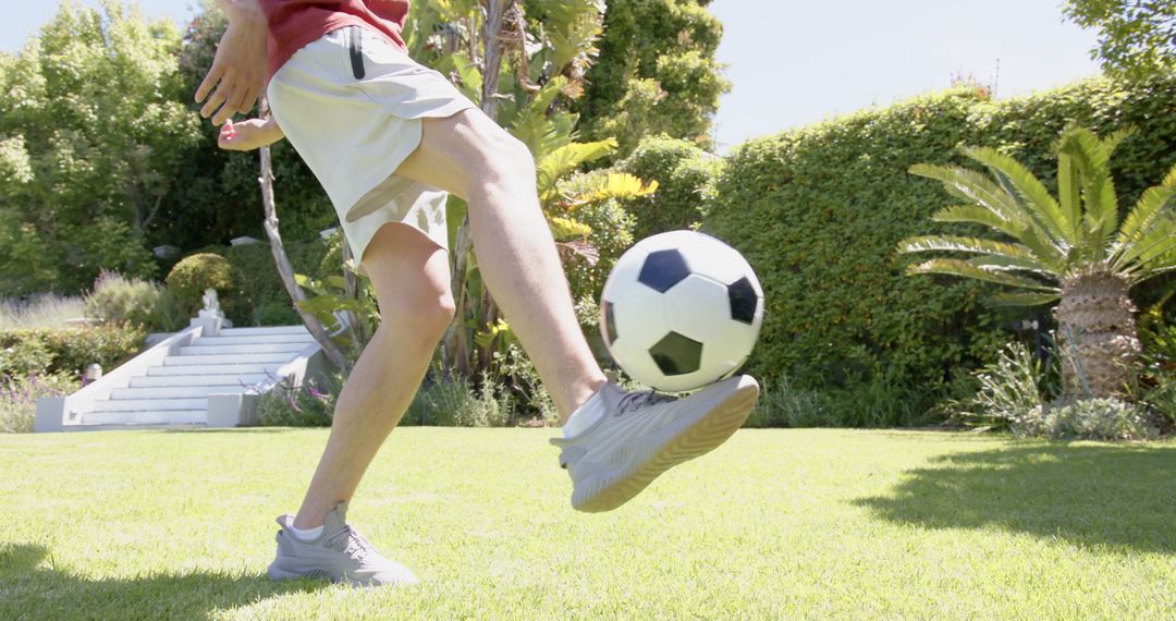 Skillful Soccer Player Practicing Kicks in Sunny Garden