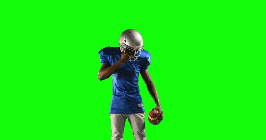 American football player in blue uniform adjusting helmet on green screen - Free Images, Stock Photos and Pictures on Pikwizard.com