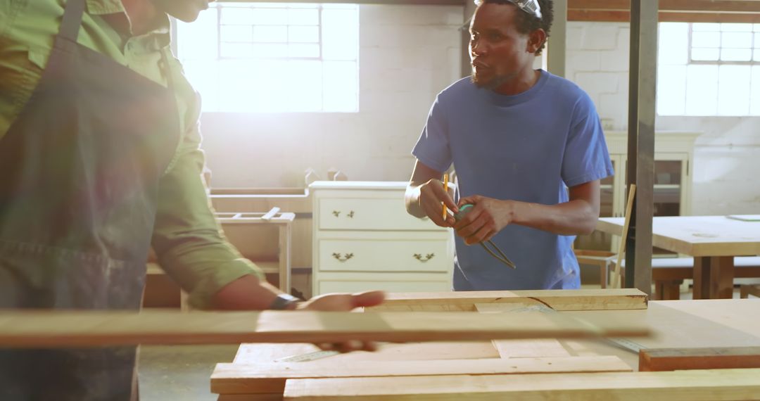 Professional Woodworkers Measuring and Collaborating in Sunlit Workshop