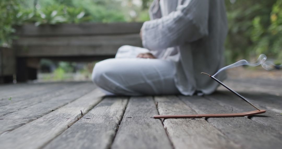 Person Meditating Outdoors with Incense on Wooden Deck - Free Images, Stock Photos and Pictures on Pikwizard.com