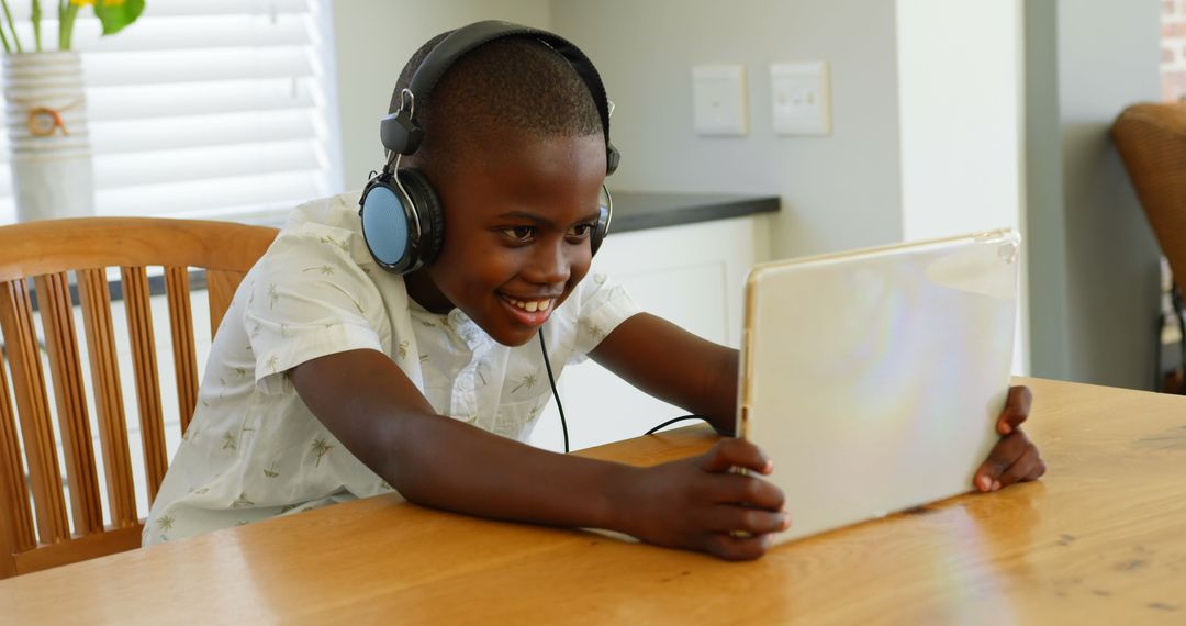 Joyful Child Using Tablet with Headphones at Home