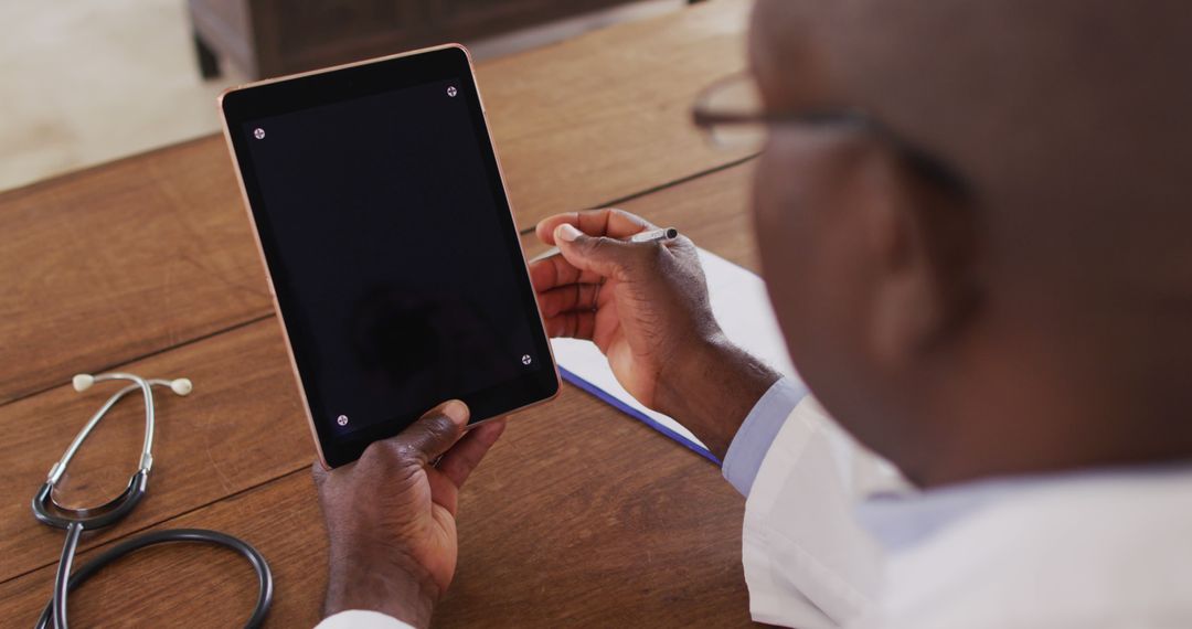 African American Doctor Using Tablet at Work Desk - Free Images, Stock Photos and Pictures on Pikwizard.com