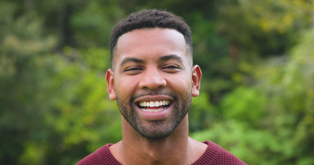 Smiling African American Man in Outdoor Setting with Greenery