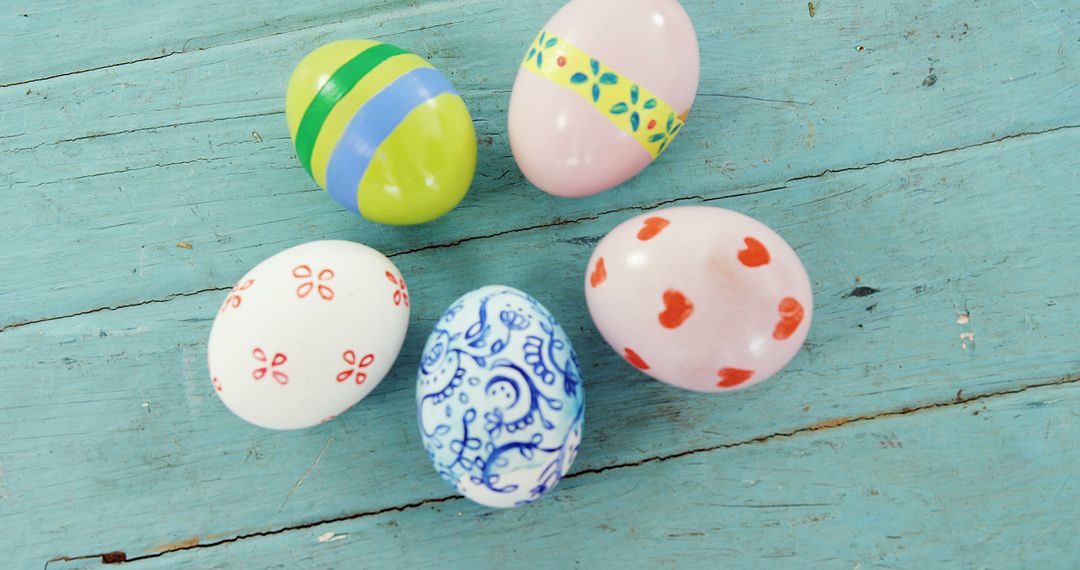 Vibrant painted eggs on blue wood embody the festive essence of Easter. - Free Images, Stock Photos and Pictures on Pikwizard.com