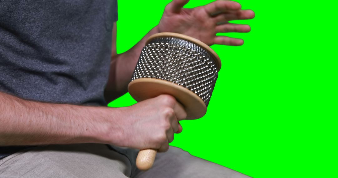 Man playing cabasa percussion instrument against green screen - Free Images, Stock Photos and Pictures on Pikwizard.com