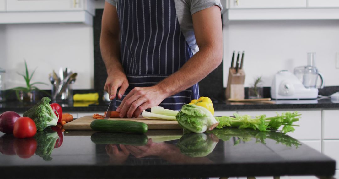 Caucasian Man in Apron Chopping Vegetables in Kitchen During Quarantine - Free Images, Stock Photos and Pictures on Pikwizard.com