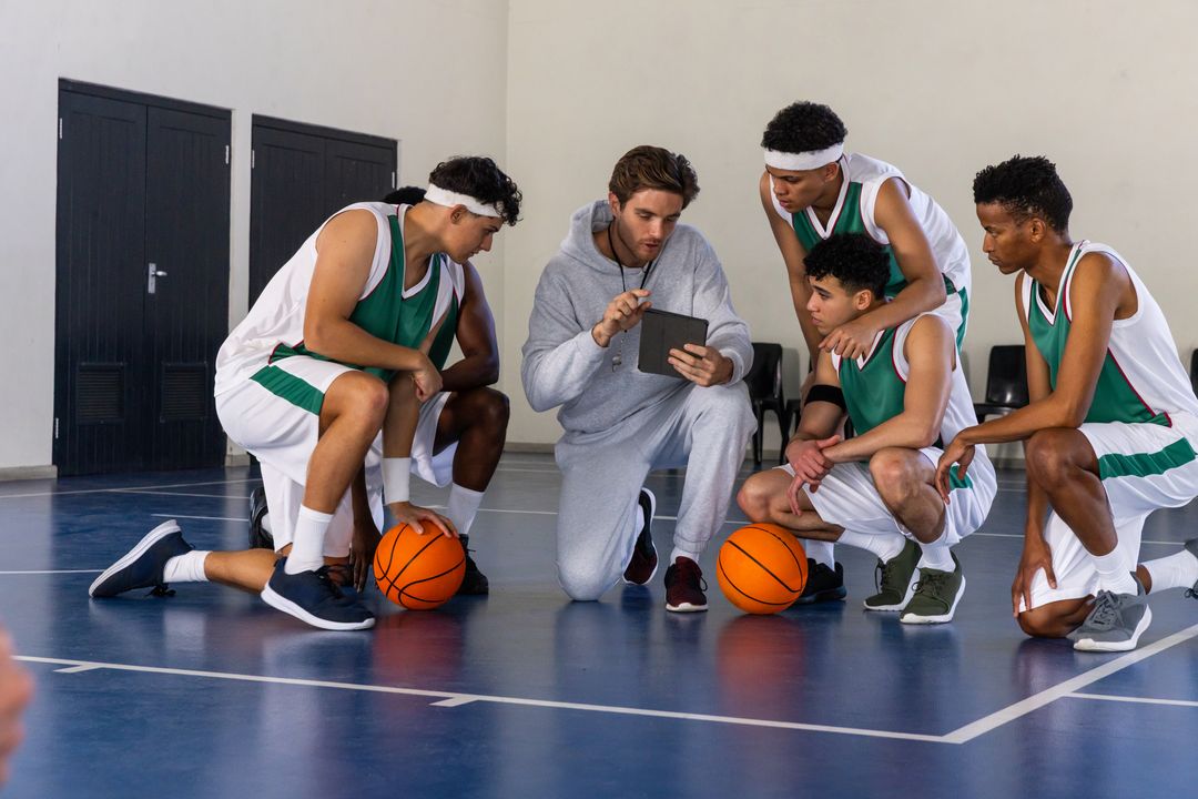 Coach Strategizing with Basketball Team Using Tablet for Game Planning