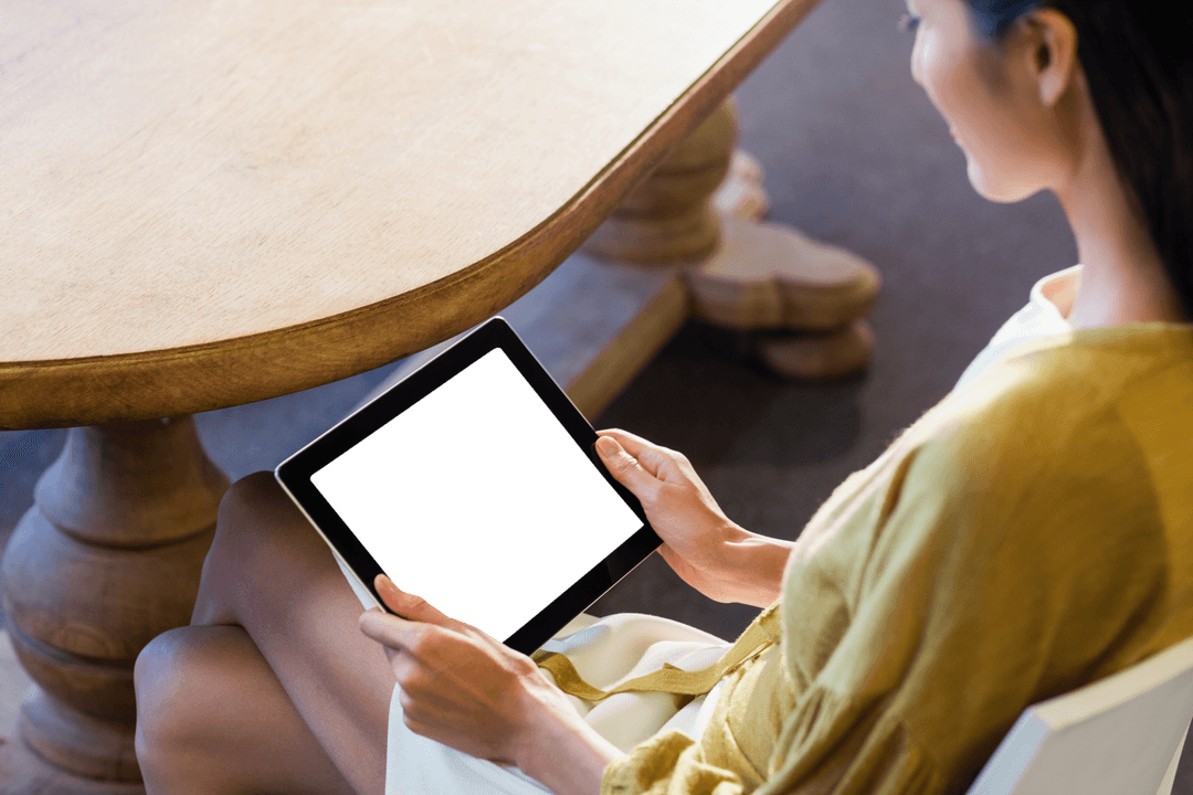 High Angle View of Woman Using Transparent Tablet by Wooden Table