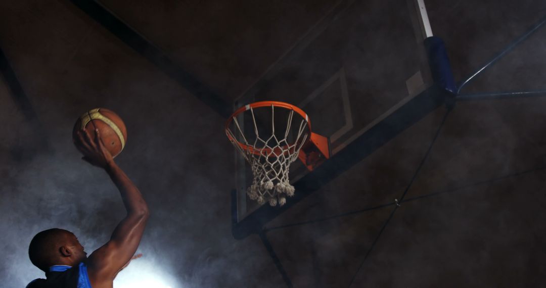 Athlete dunking basketball in smoke-filled arena - Free Images, Stock Photos and Pictures on Pikwizard.com