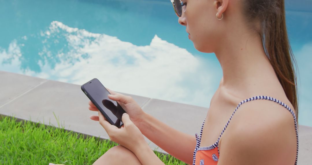 Young Woman Relaxing by Pool Using Smartphone - Free Images, Stock Photos and Pictures on Pikwizard.com