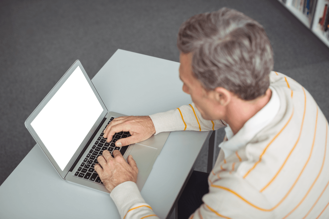 Attentive Male Teacher Using Laptop with Transparent Screen in Library
