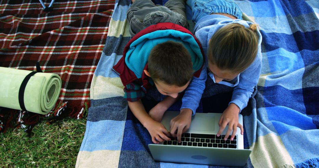 Children Using Laptop on Picnic Blanket Outdoors - Free Images, Stock Photos and Pictures on Pikwizard.com