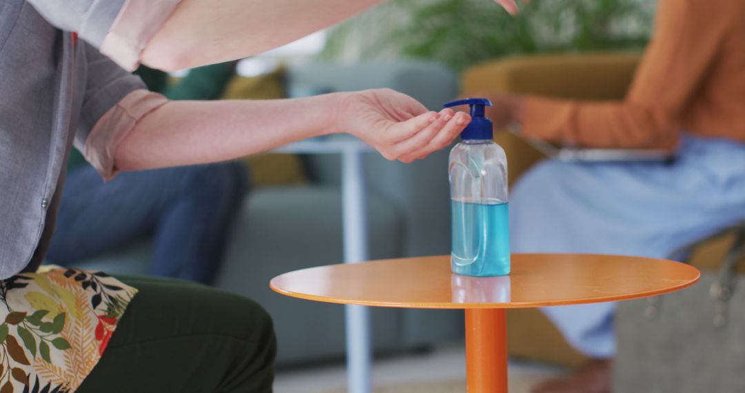 Person Using Hand Sanitizer in Modern Office Setting - Free Images, Stock Photos and Pictures on Pikwizard.com