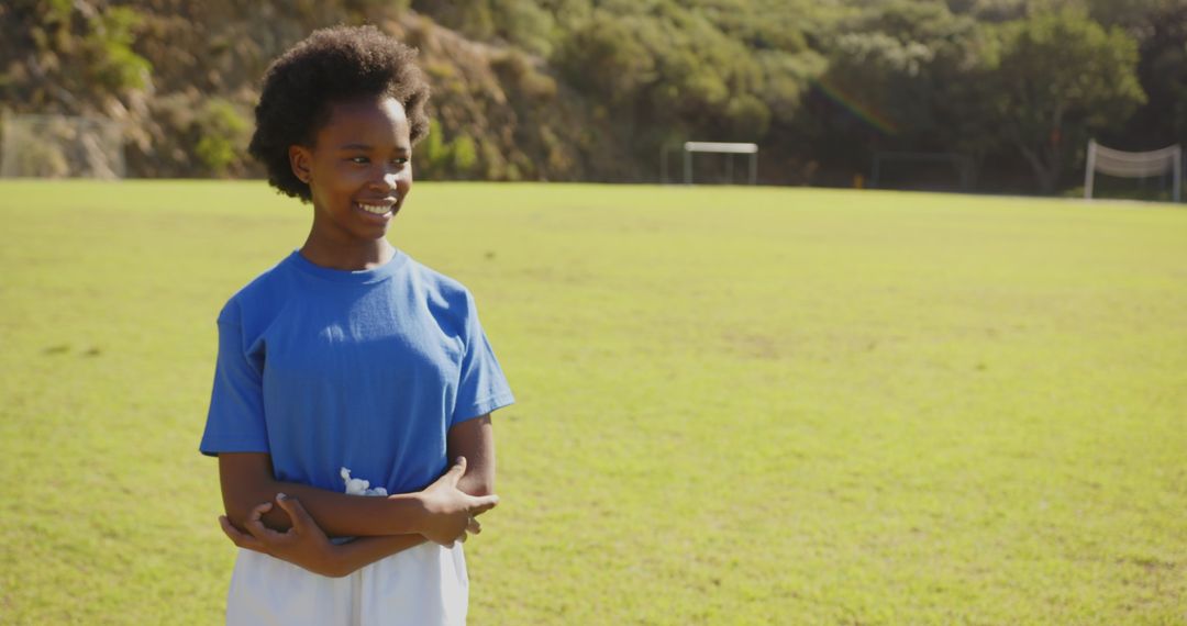 Smiling Schoolgirl on Soccer Field Under Sunlight