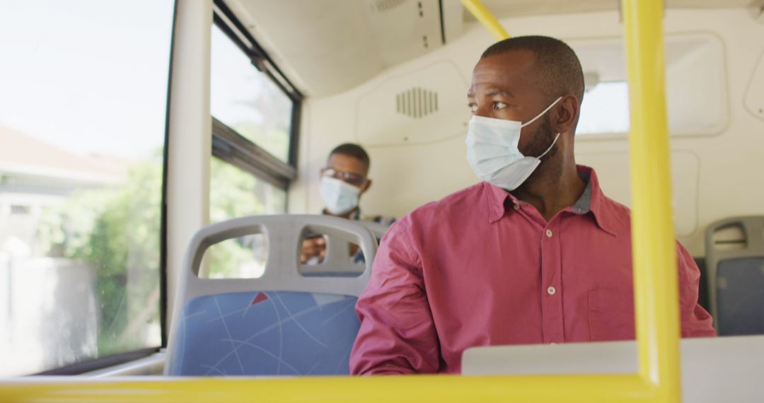 Man Wearing Face Mask Using Laptop on Bus Commute