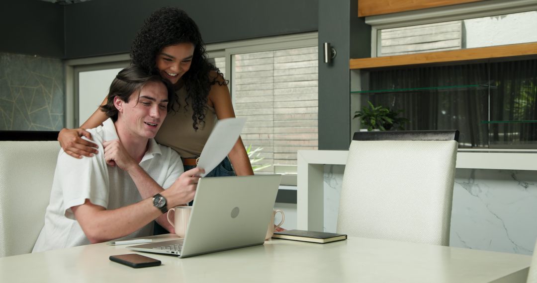 Multiracial Couple Collaborating on Work at Home with Laptop