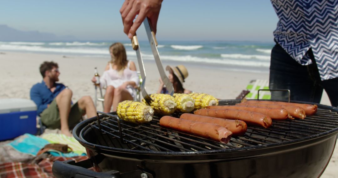 Group of Friends Enjoying Barbecue Picnic on Relaxing Beach Day - Free Images, Stock Photos and Pictures on Pikwizard.com