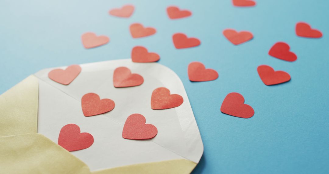 Envelope with Paper Hearts on Blue Background Symbolizing Love