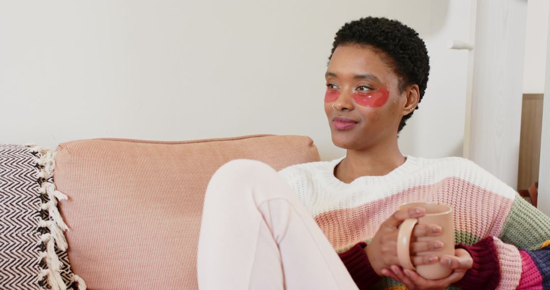Woman Relaxing on Sofa with Coffee and Eye Patches
