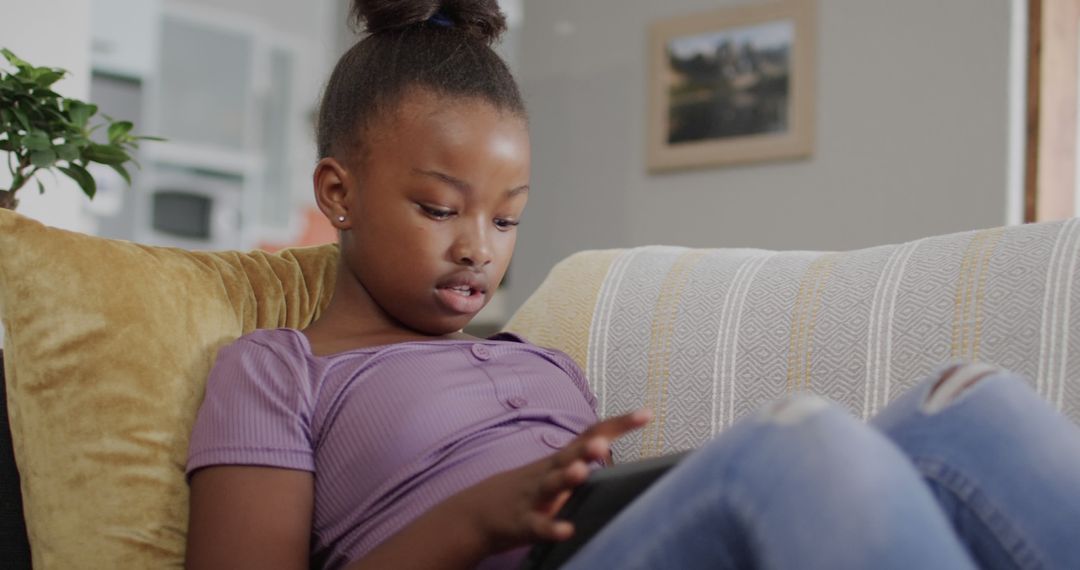 Young Girl Using Tablet on Couch in Cozy Living Room - Free Images, Stock Photos and Pictures on Pikwizard.com