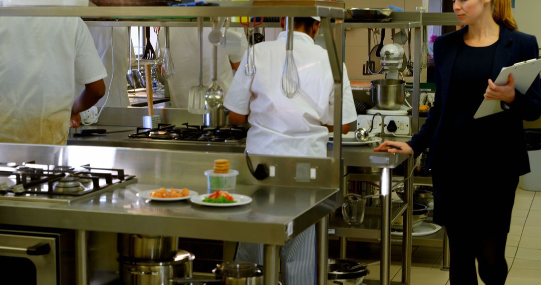 Restaurant manager supervising professional chefs working in kitchen - Free Images, Stock Photos and Pictures on Pikwizard.com