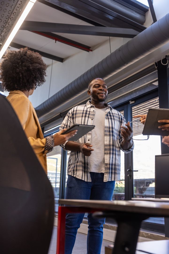 Diverse Team Collaborating in Modern Urban Office with Steel Beams