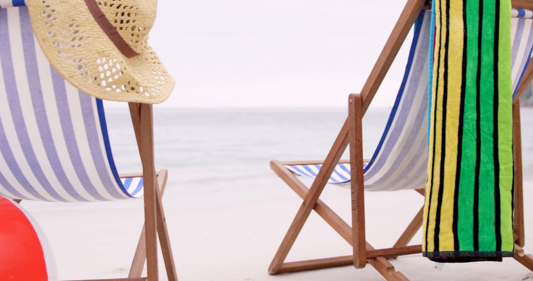 Empty Beach Chairs with Towel and Straw Hat by Ocean Background - Free Images, Stock Photos and Pictures on Pikwizard.com