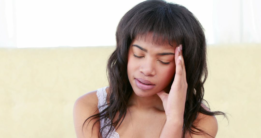 A young African American woman visibly exhibits signs of distress, possibly from pain or stress. - Free Images, Stock Photos and Pictures on Pikwizard.com