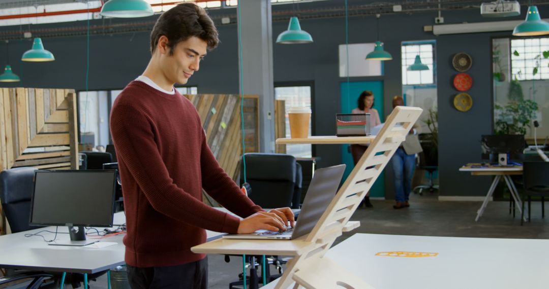 Man working at standing desk in modern office space - Free Images, Stock Photos and Pictures on Pikwizard.com